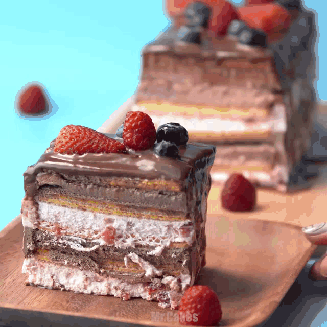 a slice of cake with strawberries and blueberries is on a plate that says mr. cakes