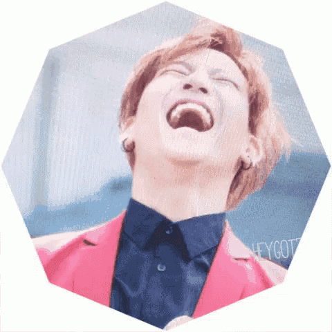 a man in a pink jacket is laughing with the word hey got on the bottom right