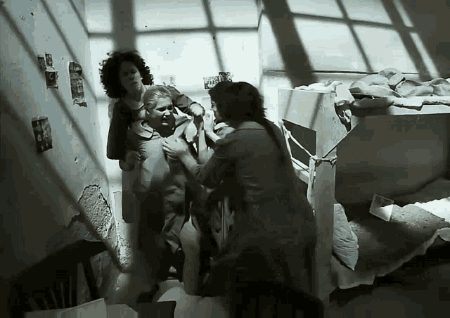 a group of people are standing around a man in a room with a sign that says ' a ' on it