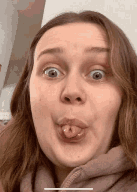 a woman is sticking her tongue out and making a funny face