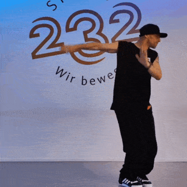 a man is dancing in front of a wall that has the number 32 on it