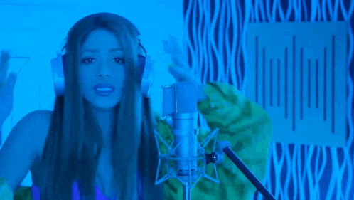 a woman singing into a microphone with the words " tas tan raro que ni te distinguo "