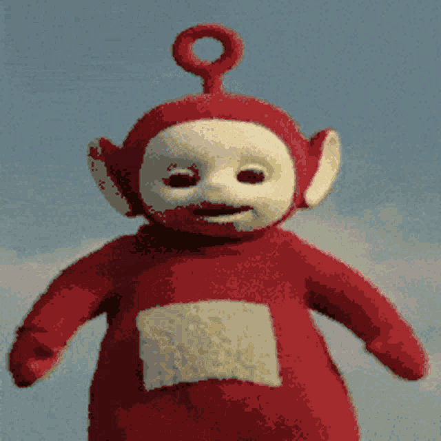 a red teletubbies doll stands in front of a cloudy sky