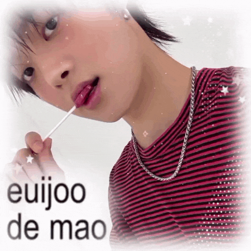 a person is holding a lollipop in their mouth and the words euijoo de mao are visible