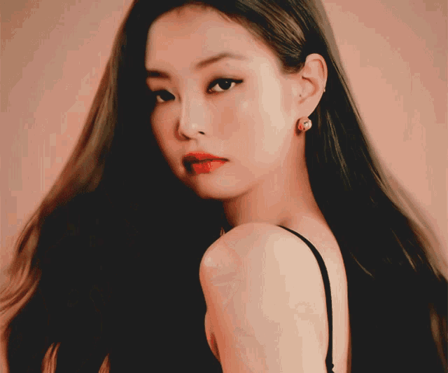 a close up of a woman 's face with long hair and earrings
