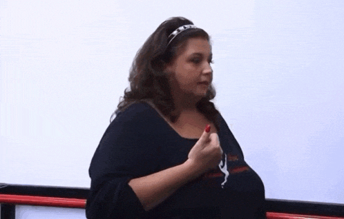 a woman with a headband on her head is holding a red nail polish in her hand .