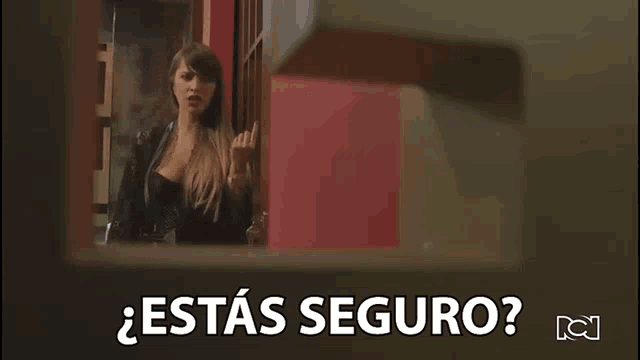 a woman is standing in front of a red wall and a sign that says estas seguro