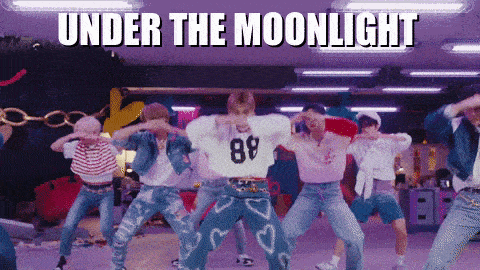 a group of young men are dancing with the words under the moonlight behind them