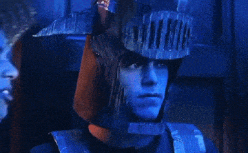 a man in a knight 's helmet is standing next to a zombie .