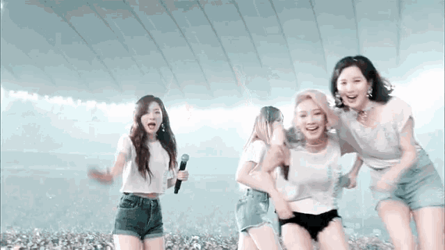 a group of women are standing next to each other on a stage .