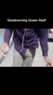 a man wearing headphones and a purple shirt is walking down a sidewalk with the words goodmorning ocean staff above him