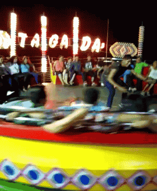 a group of people are riding a carnival ride with a sign that says taiga da