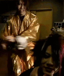 a man in a gold robe stands next to another man