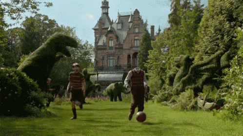 a man and a boy playing soccer in front of a castle