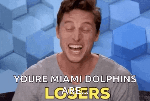 a man is laughing with the words " youre miami dolphins losers " on the bottom