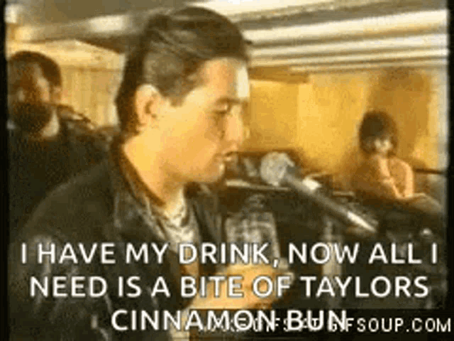 a man is talking into a microphone and saying " i have my drink now all i need is a bite of taylors