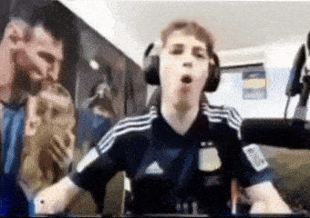a man wearing headphones is sitting in front of a large painting of messi