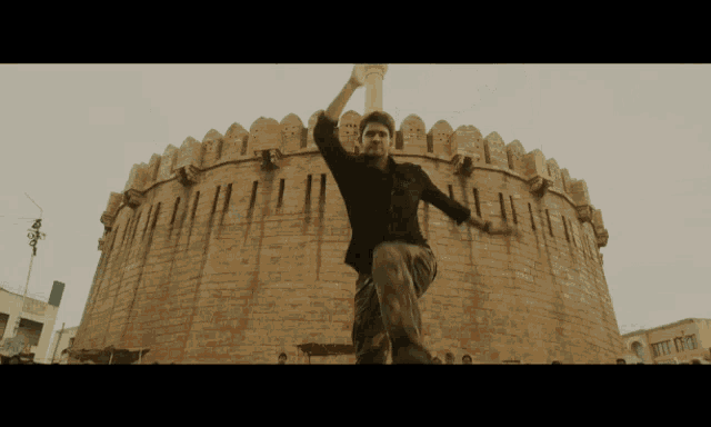 a man is standing in front of a very tall building