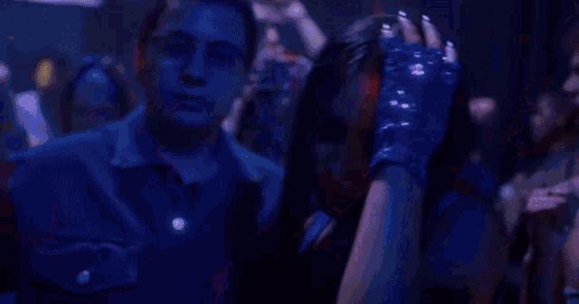 a woman with a tattoo on her arm is standing in a crowd of people at a party