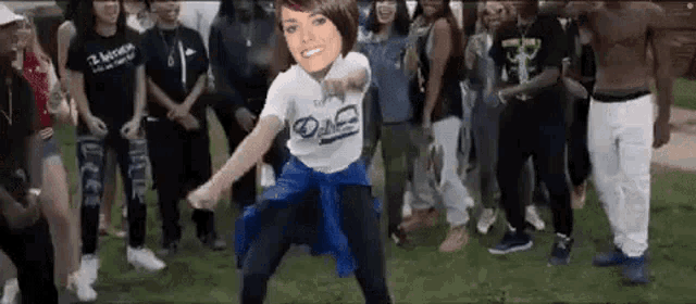 a woman is dancing in front of a crowd wearing a t-shirt that says ' o & n ' on it