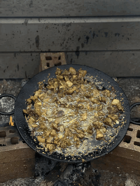 a pan filled with food is sitting on bricks