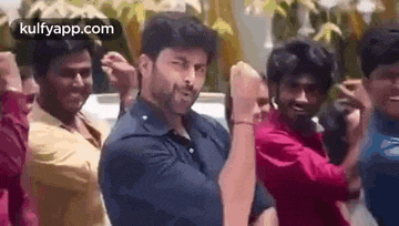 a group of men are standing next to each other dancing .