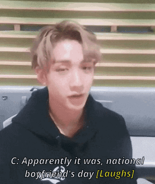 a young man in a black hoodie is laughing while talking about a national boyfriend 's day .
