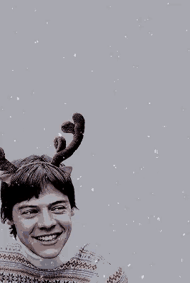 a man wearing reindeer antlers and a sweater smiles