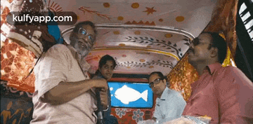 a group of people are sitting in a rickshaw with a fish on the screen ..