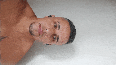 a shirtless man with a beard and a tattoo on his chest