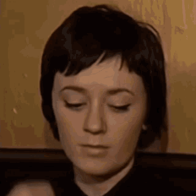 a close up of a woman with her eyes closed .
