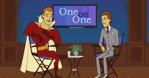 a man in a superhero costume is sitting in front of a one on one tv show