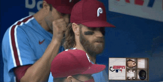 a baseball player wearing a red hat with a letter p on it
