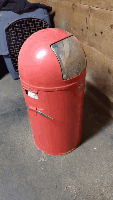 a red trash can with a lid that says ' a ' on it