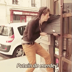 a man standing in front of a door with the words putain de merde on the bottom