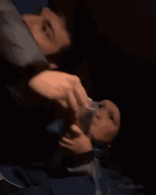 a man and a child are sitting in a dark room .