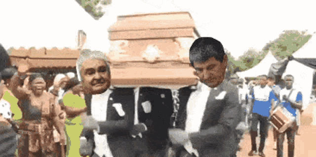a man in a suit is carrying a coffin with two faces on it