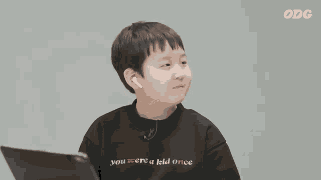 a young boy wearing a black sweater that says you were a kid once