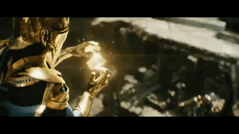 a man in a gold armor is holding a glowing object in his hands .