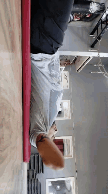 a person laying on a red mat with their legs crossed