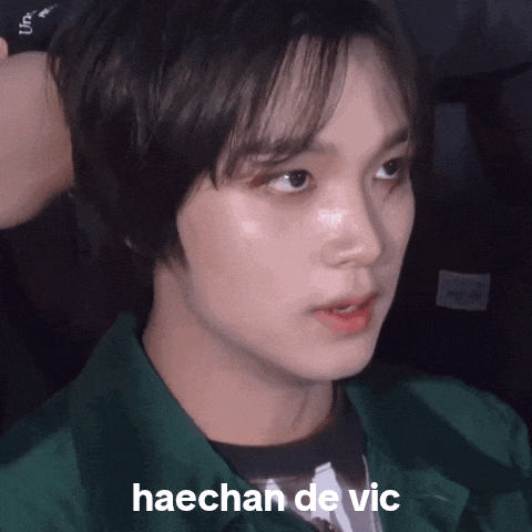 a close up of haechan de vic 's face with a green jacket