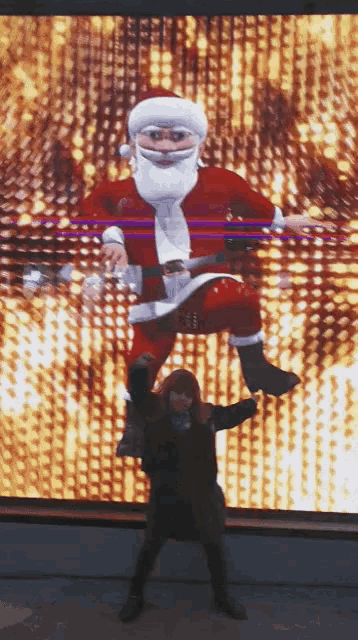 a woman is standing in front of a santa claus display