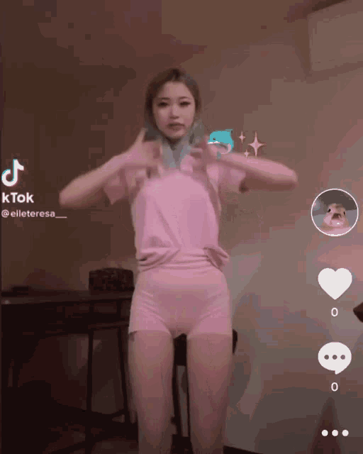 a woman in a pink shirt and shorts is dancing on a tik tok video