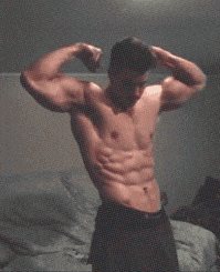 a shirtless man flexing his muscles in front of a mirror
