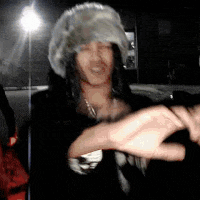 a woman wearing a fur hat and a necklace is dancing
