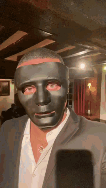a man wearing a black mask and a white shirt
