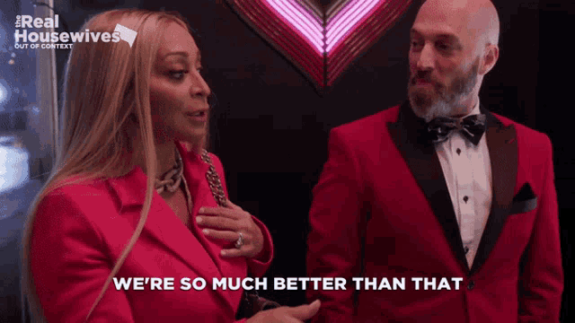 a woman in a red jacket says " we 're so much better than that " next to a man in a red tuxedo