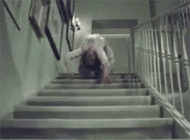 a person is doing a handstand on a set of stairs in a dark room .
