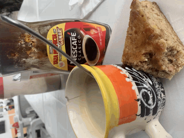 a bottle of nescafe classico is next to a cup of coffee