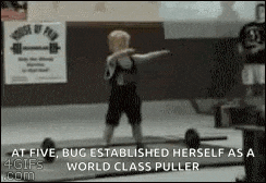a young boy is lifting a barbell in a gym and making a funny face .